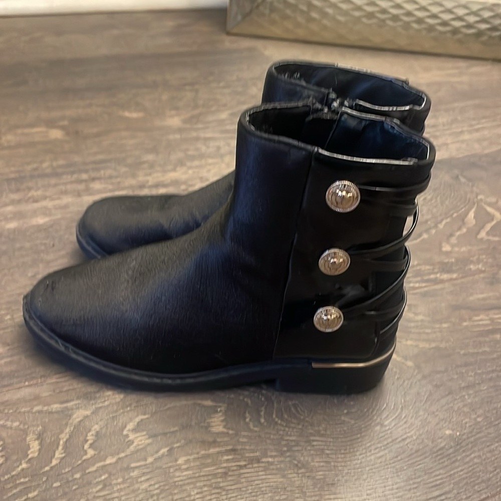 Black boots with gold buttons on the sides.